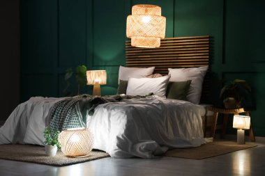 Şık bir yatak odası, rahat bir yatak odası, çiçekler ve geceleri parlayan lambalar.