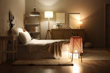 Şık bir yatak odası, rahat bir yatak ve geceleri parlayan lambalar.