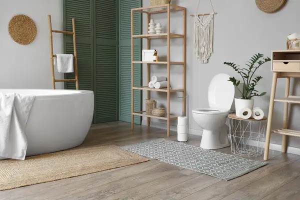 İçinde klozet, küvet ve raf ünitesi olan bir oda.