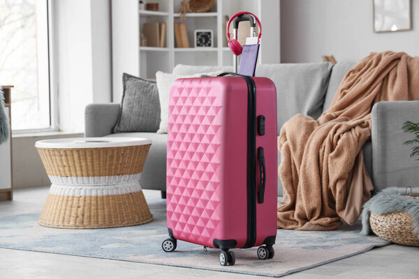 Интерьер гостиной с чемоданом, наушниками и паспортом