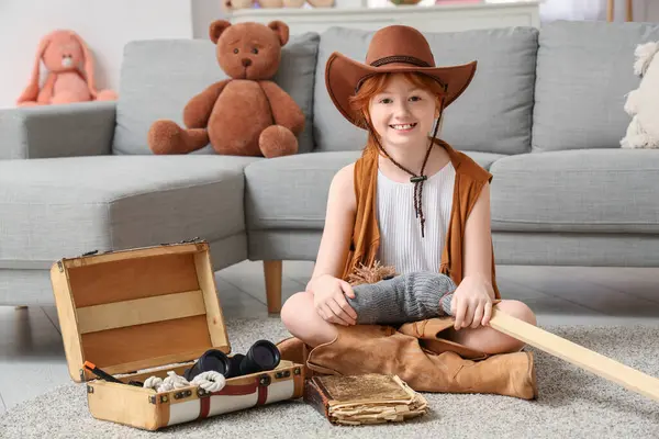 Evinde bavul ve kovboy ekipmanıyla şapkalı sevimli mutlu genç kız.