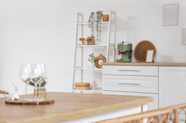 Bardaklar, figür ve ev bitkisi yemek masasında, aydınlık mutfakta, yakın plan.