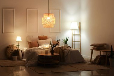 Şık bir yatak odası, rahat bir yatak odası, çiçekler ve geceleri parlayan lambalar.