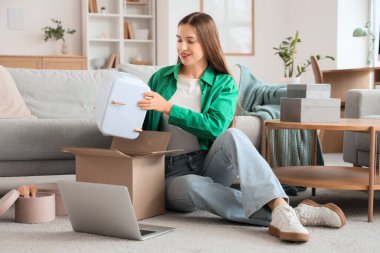 Evinde yeni kozmetik buzdolabını açan mutlu genç moda blogcusu.