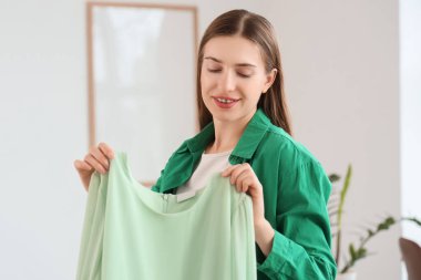 Mutlu genç moda blogcusu evinde yeni moda elbiseler açıyor.
