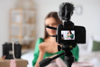 Mutlu genç moda blogcusu yeni moda aksesuarlarını açarken kameraya video kaydediyor.