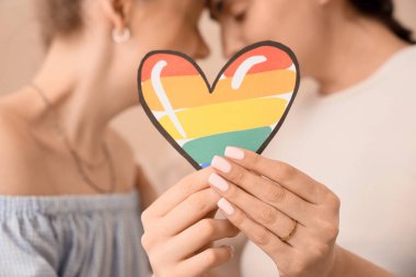 Evde LGBT kalbi olan genç hamile lezbiyen çift, yakın plan.