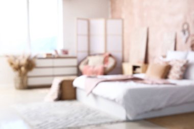 Rahat yataklı, katlanır ekran ve pencereli şık yatak odasının bulanık görüntüsü