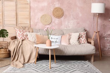 Beyaz kanepesi, kahve masası ve standart lambası olan şık bir oturma odası.