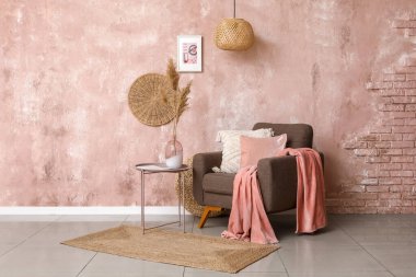 Kahverengi koltuklu ve kahve masasında çim pampası olan şık bir oturma odası.