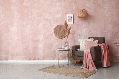 Kahverengi koltuklu ve kahve masasında çim pampası olan şık bir oturma odası.