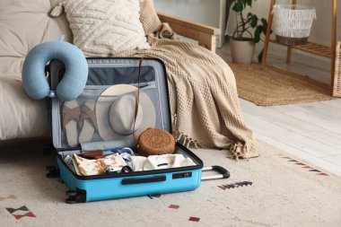 Giysileri ve seyahat aksesuarlarıyla dolu bavulları oturma odasına yerleştirdim.