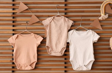 Tahta kafese asılmış bayraklı bebek kıyafetleri.