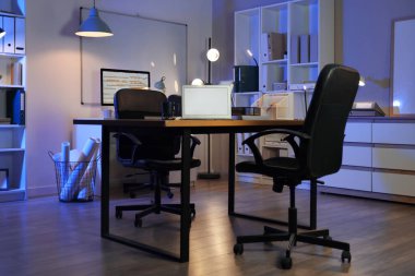 Boş dizüstü bilgisayar gece ofis içinde masanın üzerinde.