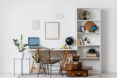 Çalışma yeri, raf ünitesi ve antika bavullu hafif ofis.