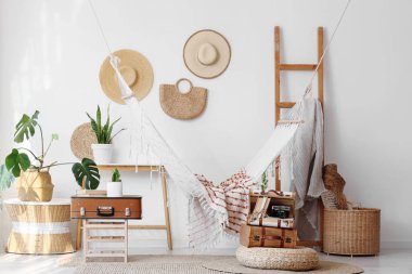 Hamak, antika bavullar ve bitkilerle aydınlatma odasının içinde.