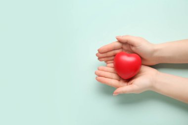 Yeşil arka planda kalbi olan bir kadın eli. Dünya Sağlık Günü