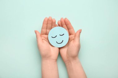 Yeşil arka planda kağıt tebessümlü kadın elleri. Dünya Sağlık Günü