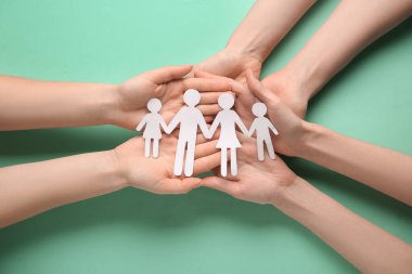 Yeşil arka planda çocuk figürleri olan kadın eller. Dünya Sağlık Günü