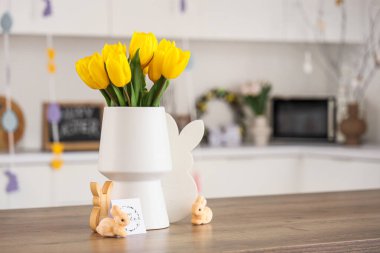 Laleli vazo, paskalya tavşanı ve mutfak masasında kart.