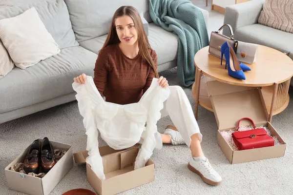 Mutlu genç moda blogcusu evinde yeni şık bir gömlek açıyor.