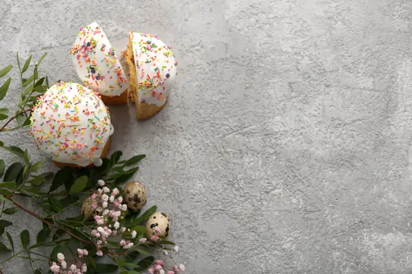 Bıldırcın yumurtalı tatlı Paskalya pastaları ve gri arka planda çingene çiçekleri.