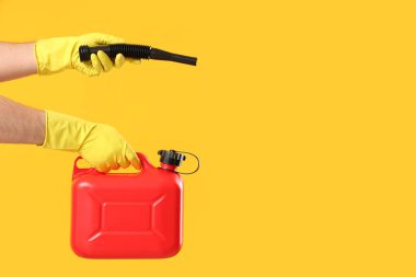 Erkek eller sarı arka planda teneke kutu ve lastik başlık tutuyor.