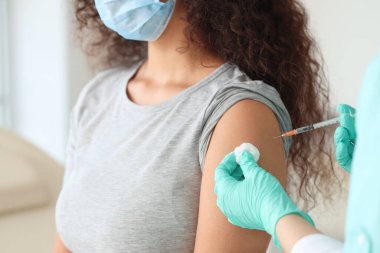 Kadın doktor klinikte aşı yapıyor, yakın plan.