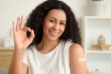 Genç Afro-Amerikalı kadın, evde aşı yaptıktan sonra iyi görünüyor.