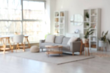 Gri kanepe, işyeri ve ayna ile aydınlık oturma odasını bulanık görmek