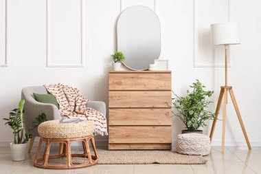 Oturma odasının içinde koltuk, ayna ve tuvalet var.