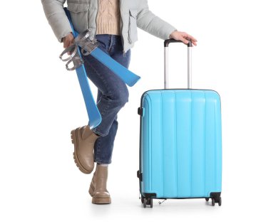 Beyaz arka planda bavulu ve kayağı olan bir kadın turist.