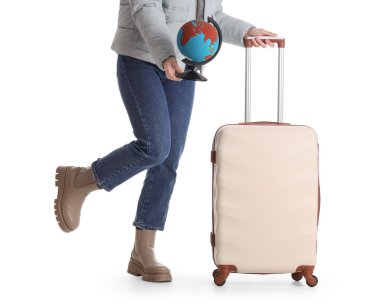 Beyaz arka planda bavulu ve küresi olan kadın turist