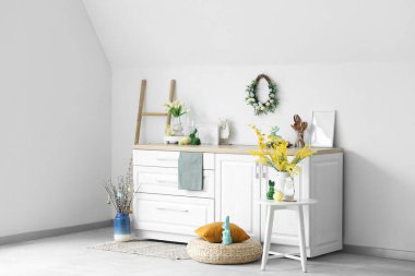 İçinde merdiven, güzel çiçekler, çatal bıçak ve tezgahta Paskalya süslemeleri olan festival mutfağı.