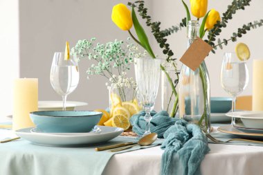 Lokantada güzel lale çiçekleri ve altın çatal bıçak takımı olan zarif bir masa.