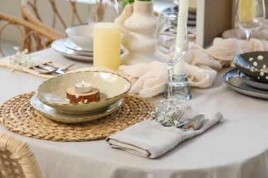 Restoranda temiz tabaklar ve güzel çiçekler olan zarif bir masa.