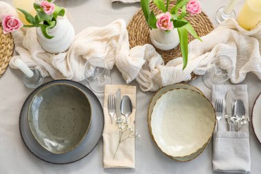 Lokantada güzel lale çiçekleri, mumlar ve temiz tabaklar olan şık bir masa.