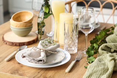 Güzel çiçekleri ve okaliptüs dalları olan şık masa ayarı hafif mutfakta, yakın plan.