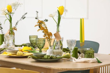 Aydınlık odada bahar çiçekleri olan masa ayarı