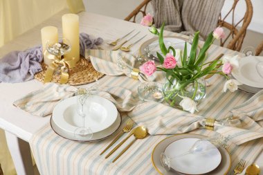 Bahar çiçekleri ve mumlarla dolu güzel bir masa.