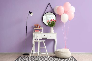 Kadınlar Günü için makyaj masası, lamba ve balonlarla süslenmiş soyunma odasının içi.