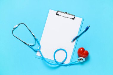 Steteskoplu boş bir pano ve mavi arka planda kırmızı kalp. Dünya Sağlık Günü