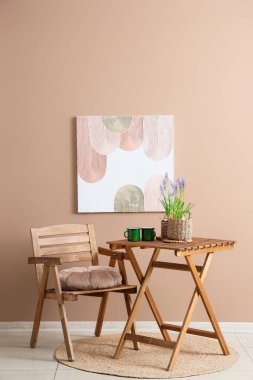 Güzel Muscari çiçekleri masada fincanlar ve odada bej duvarın yanında sandalye.