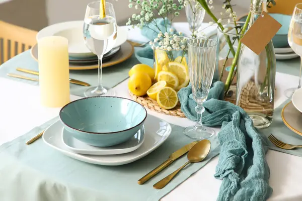 Lokantada güzel lale çiçekleri ve altın çatal bıçak takımı olan zarif bir masa.