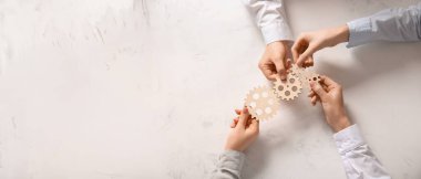 Eller arka planda ahşap dişlileri tutuyor, üst manzara