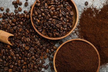 Kahve çekirdekli kaseler ve gri arka planda pudra.