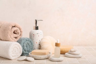 Hafif fayans masasında gerekli yağ şişesiyle banyo malzemeleri.