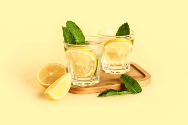 Arkaplanda soğuk mojito, limon ve nane içeren ahşap bir tahta.