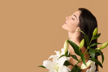 Beyaz zambak çiçekleriyle güzel genç bir kadın, yakın plan.