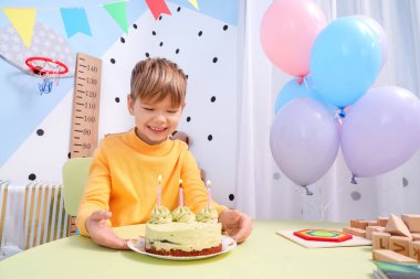 Evde doğum gününü kutlayan tatlı küçük bir çocuk.